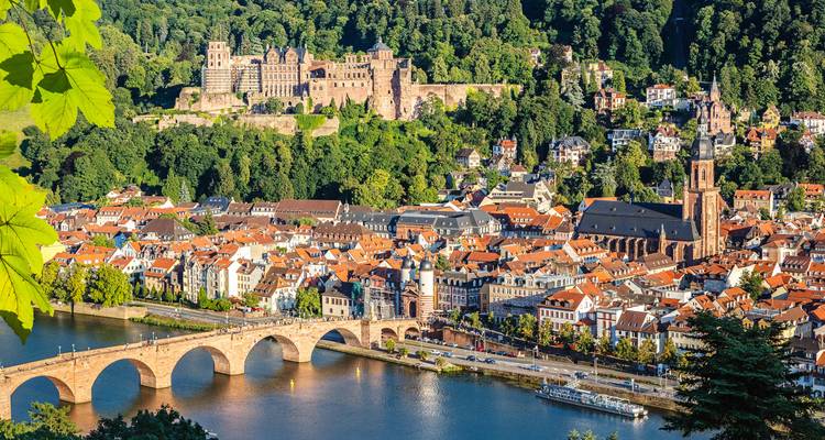 Heidelberg city view with a bridge over the river and a castle on a hill.