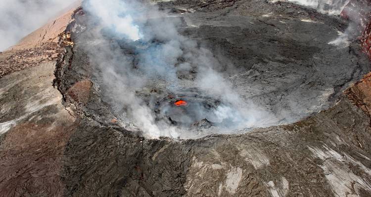 Vulkanische krater met rook en lava zichtbaar aan de binnenkant.