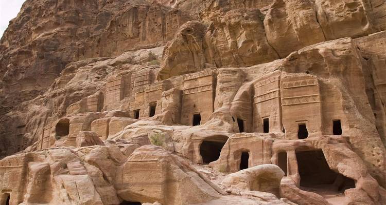 Serie van in rotsen uitgehouwen tombes met rechthoekige ingangspartijen uitgehakt in een rotsenwand in het Royal Tombs-gebied van Petra.