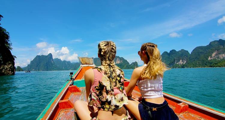 Deux personnes assises dans un bateau entouré de montagnes pittoresques.