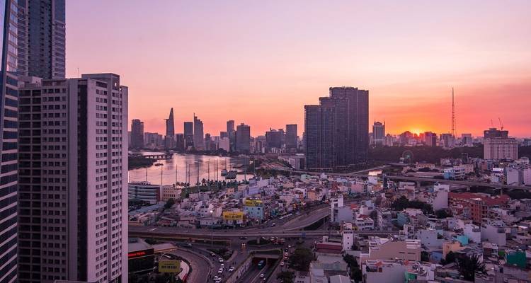 Cityscape of Ho Chi Minh City during sunset with high-rise buildings.