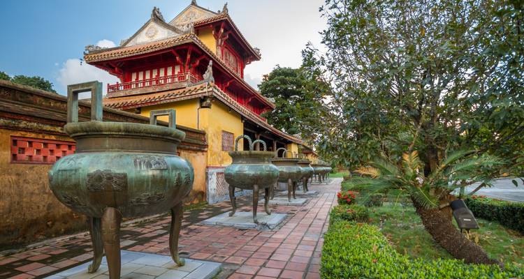 Antike Struktur mit großen Bronzegefäßen in einem Innenhof.