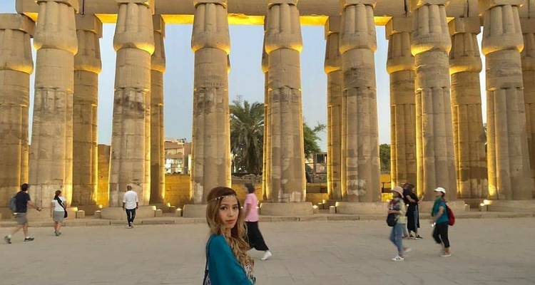 Menschen erkunden antike Säulen vor historischer Kulisse