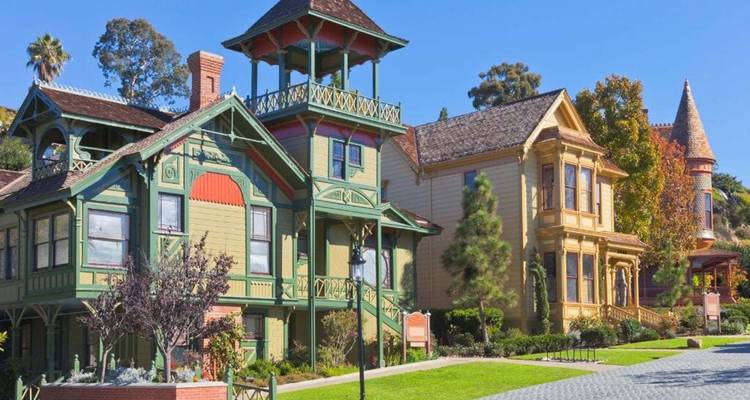 Colorful Victorian-style houses in a sunny neighborhood.