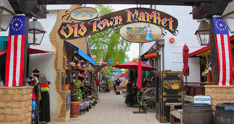 Colorful market street with signs and decorations.