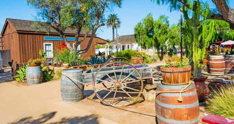 Traditional outdoor area with barrels and a wooden wagon.