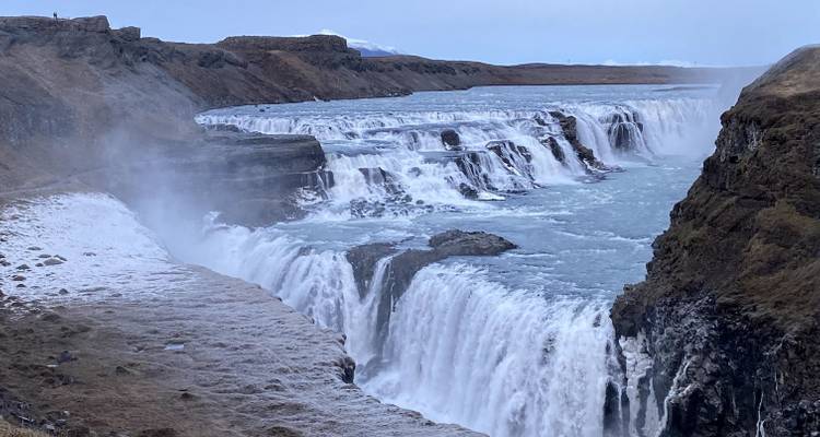 Puissante cascade dévalant une falaise rocheuse.