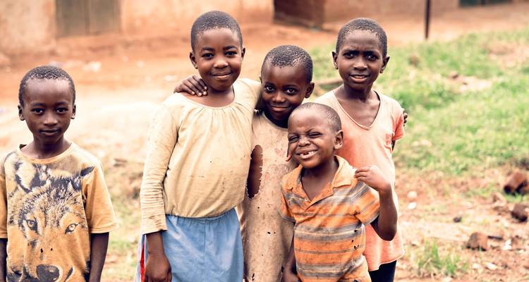 Groupe d'enfants posant pour une photo dans un cadre extérieur.