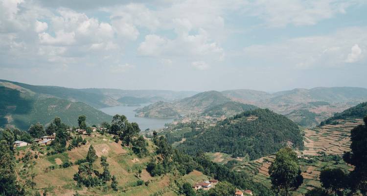 Paysage vallonné avec un lac et des villages dispersés.