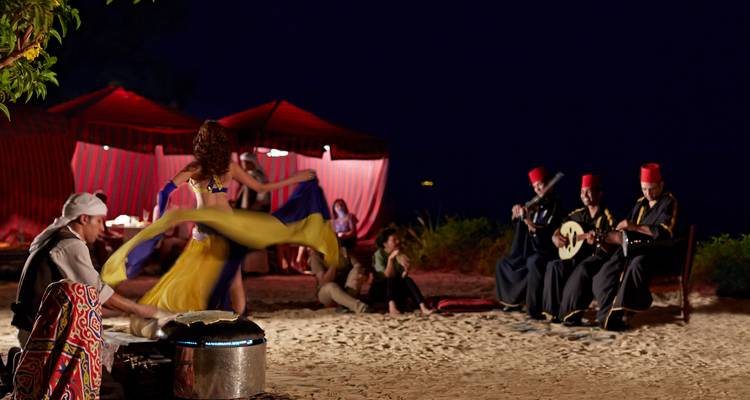 Eine nächtliche Kulturaufführung am Strand mit Musikern und Tänzern.