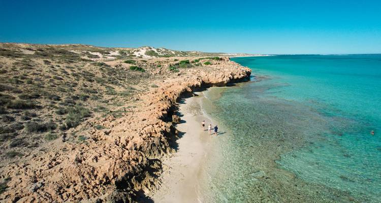 Vue aérienne de la côte rocheuse de corail avec une eau turquoise cristalline et une plage de sable étroite le long de la barrière de Ningaloo.