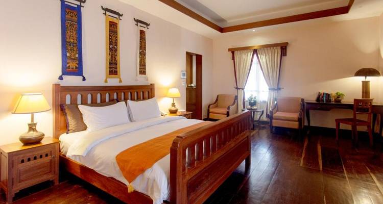 Elegant bedroom with wooden furnishings and warm lighting.