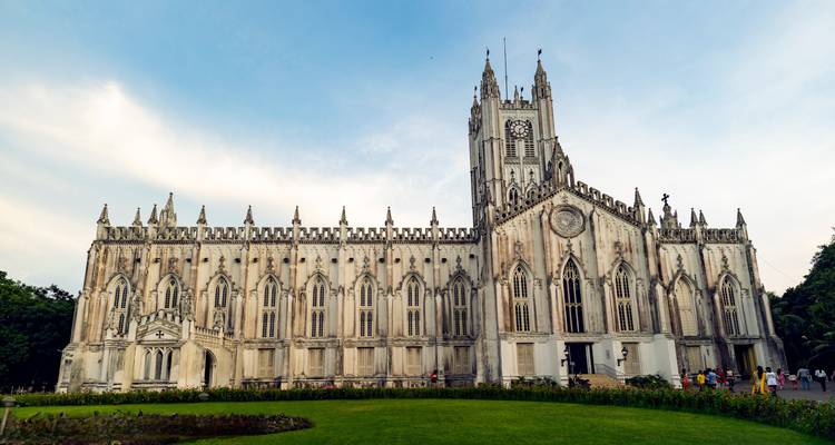 Gran edificio de iglesia de estilo gótico con un césped al frente.