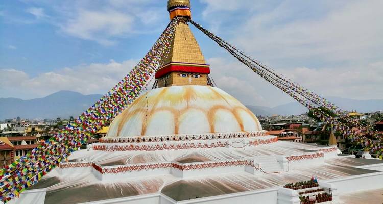 Vue large d'un stupa avec des drapeaux de prière colorés.