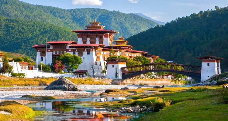 Punakha Dzong au bord d'une rivière avec des collines luxuriantes au Bhoutan.