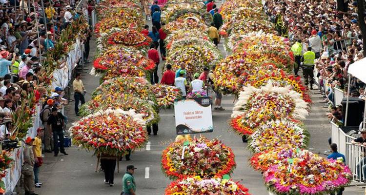 Parade with people carrying large floral arrangements.