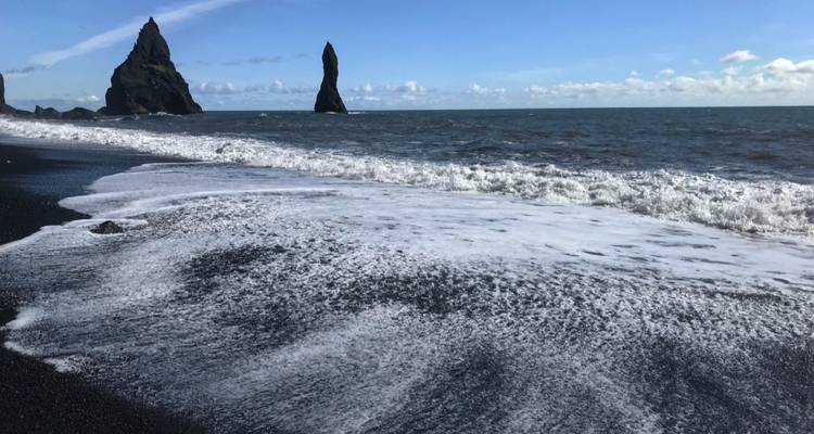 Reynisdrangar Cliffs and ocean waves at Reynisfjara Beach in Iceland.