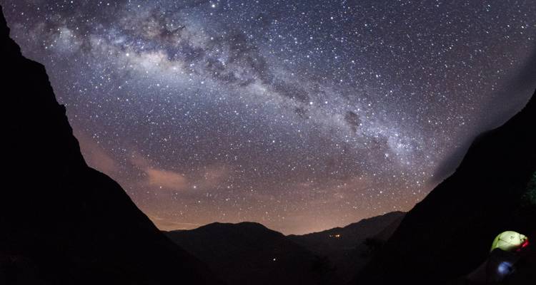 Starry night sky with the Milky Way in between mountains.