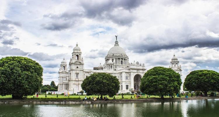 Victoria-Denkmal mit üppigen Bäumen und einem Spiegelteich.