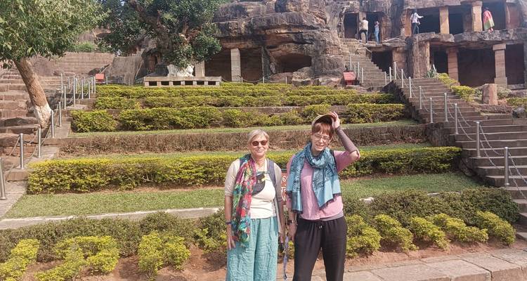 Zwei Personen posieren vor antiken in Fels gehauenen Strukturen.