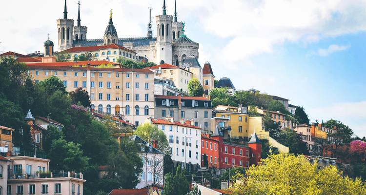 Colorful hillside houses climbing toward the ornate basilica with multiple spires overlooking the city.