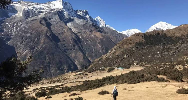 Hiker traversing a mountainous landscape.