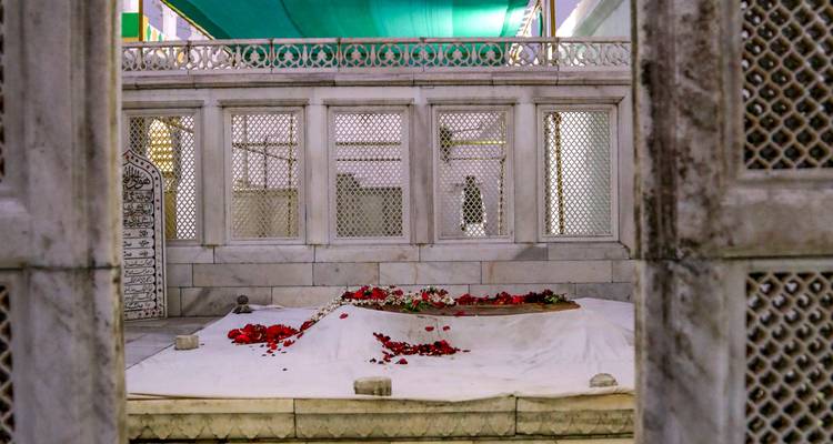 Ein Marmorgrab mit verstreuten Blütenblättern ringsum.