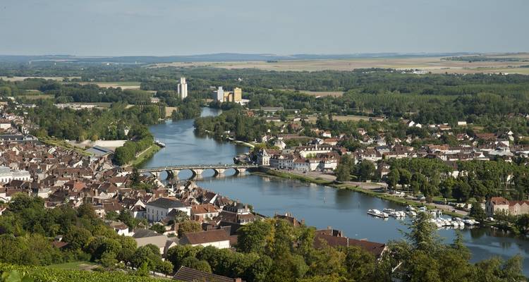 Luftaufnahme einer Stadt mit einem Fluss und der umliegenden Landschaft.