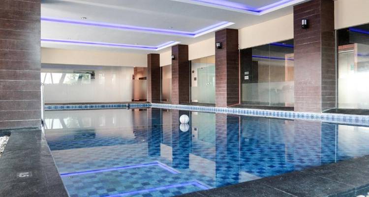Indoor swimming pool with modern tiles and lighting.