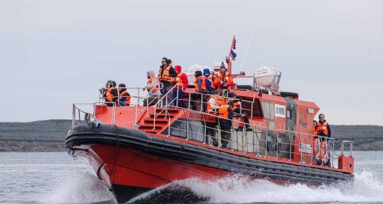 Menschen auf einem Boot, die während einer Meeresexpedition Rettungswesten tragen.