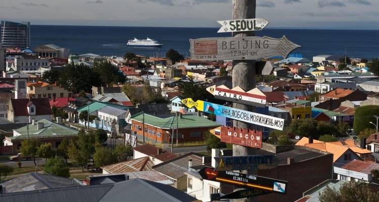 Blick auf bunte Dächer in einer Küstenstadt mit Richtungsschild.