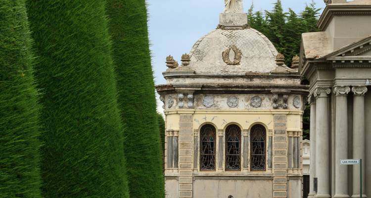 Ein historischer Friedhof mit kunstvollen Mausoleen und hohen Hecken.