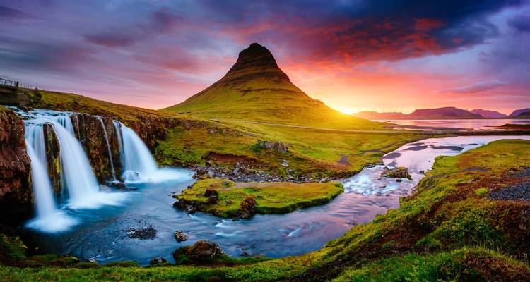 Cascade pittoresque avec une montagne au coucher du soleil.