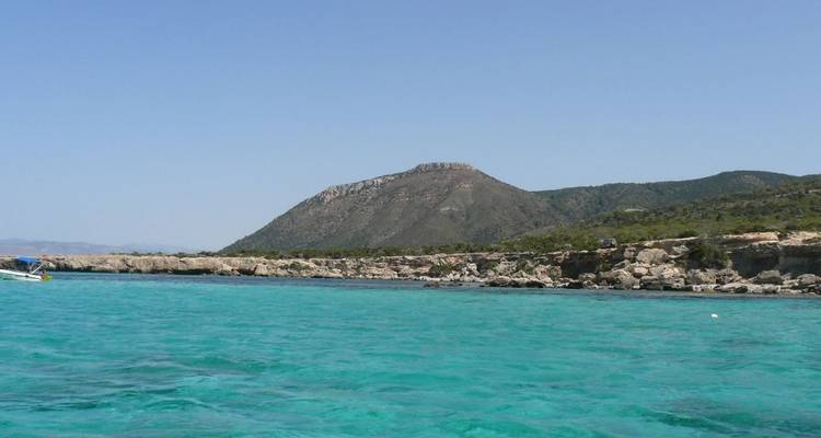 Clear turquoise sea with mountainous coastline.