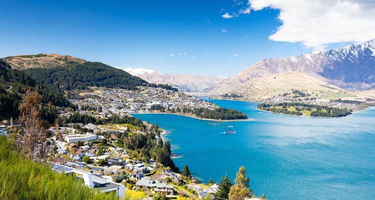 Vue époustouflante sur Queenstown et le lac Wakatipu avec des montagnes enneigées et une eau d'un bleu profond.