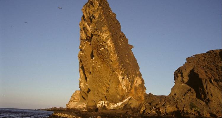 A prominent rocky outcrop against a blue sky.