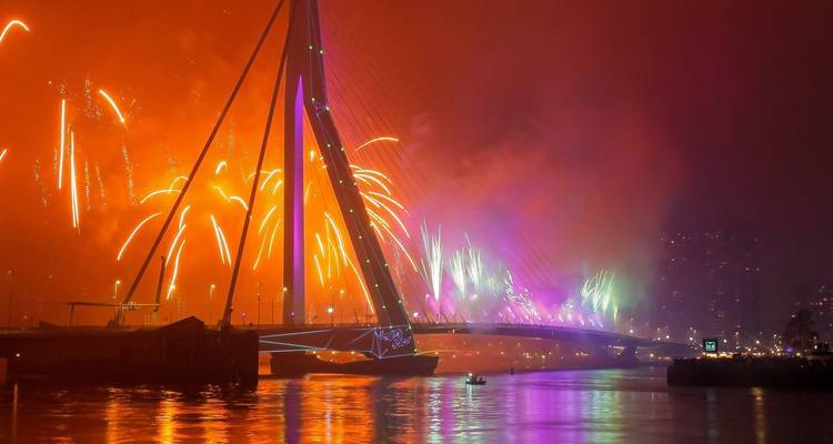 Spektakuläre Feuerwerke erleuchten nachts die Erasmus-Brücke und den Fluss in Rotterdam.