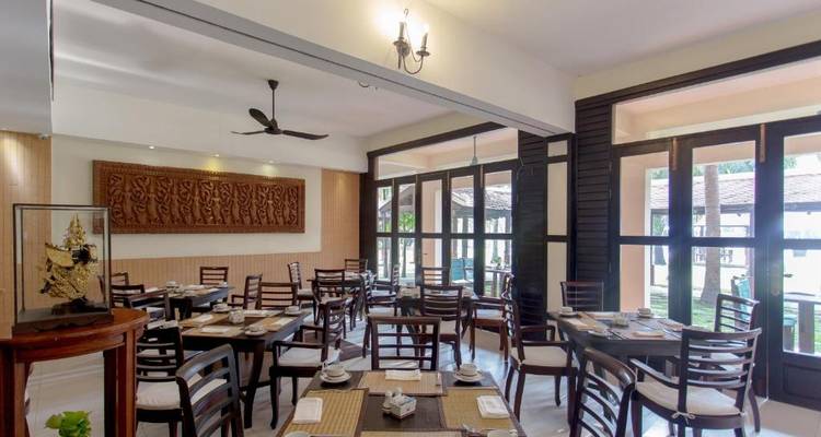 Bright dining area with arranged tables and cultural wall art.