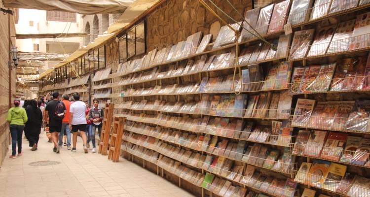 Allée de librairie animée avec des livres exposés sur les étagères.