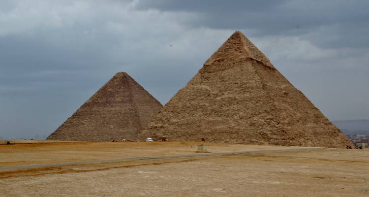 Les Grandes Pyramides de Gizeh sous un ciel nuageux.