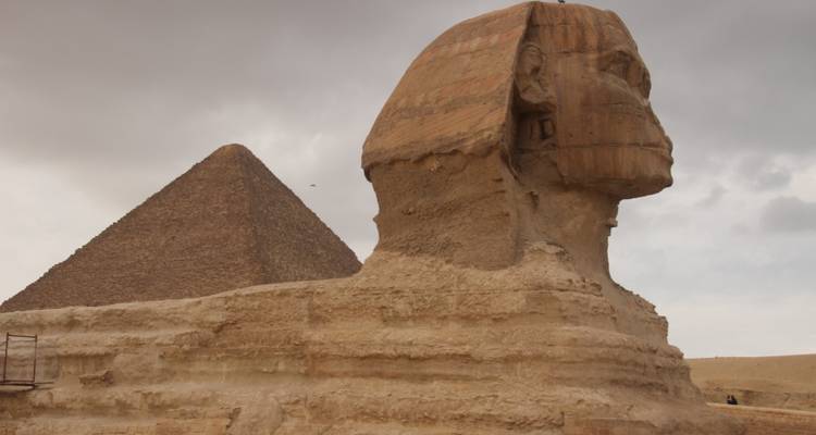 Sphinx et pyramide sous un ciel couvert.
