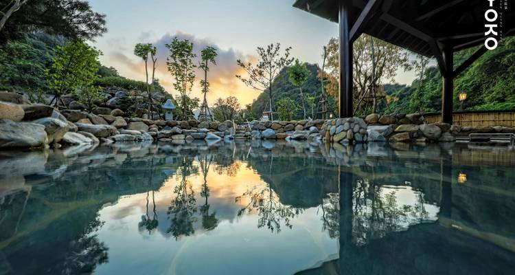 Outdoor hot spring with a scenic view during sunset.