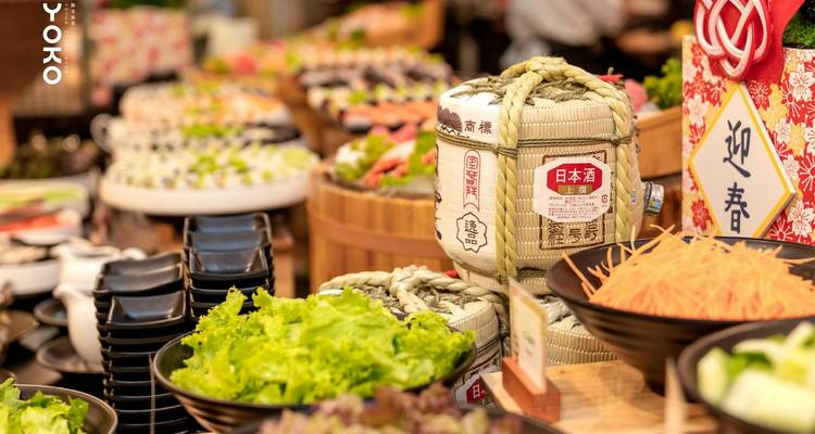 A buffet display with sushi and a sake barrel.