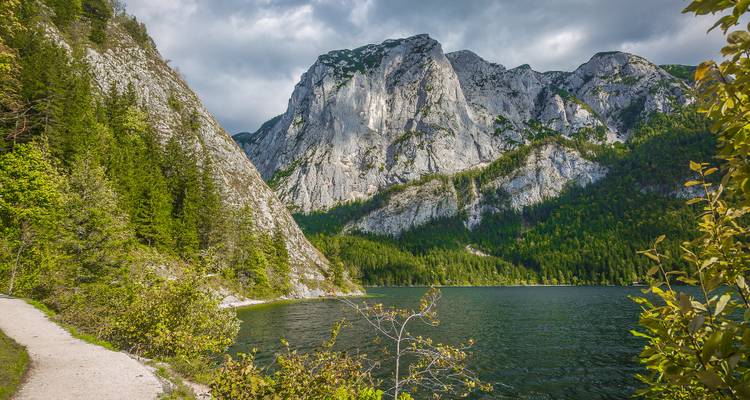 Path by the lake with mountains in the background.