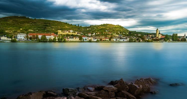 Malerische Uferpromenade in der Wachau mit Weinbergen.