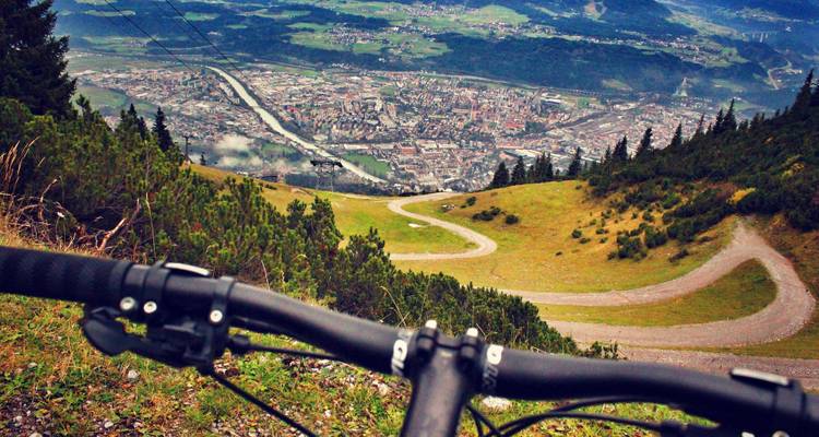 Bicycle overlooking a winding path and city below.