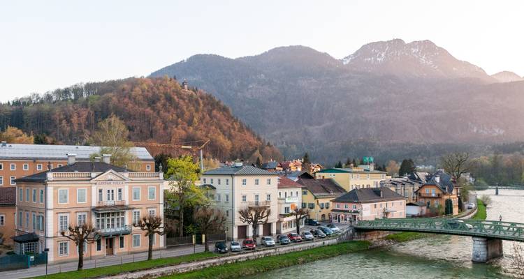Charmante ville au bord d'une rivière avec des montagnes en arrière-plan.