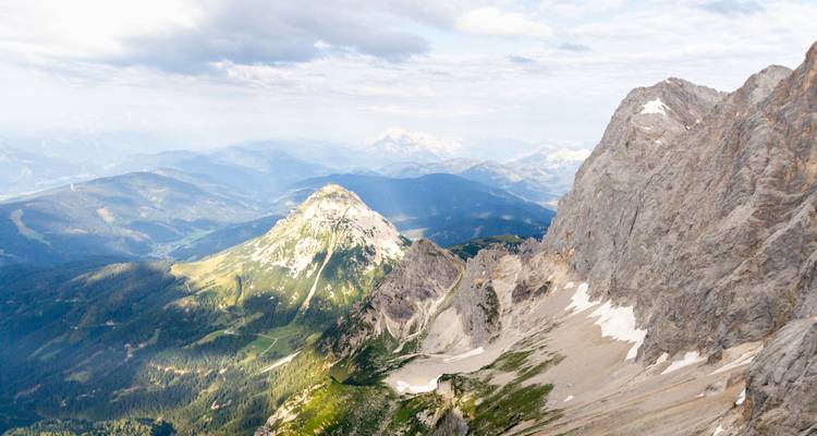 Une vue de montagne avec des pics rocheux et des vallées vertes.