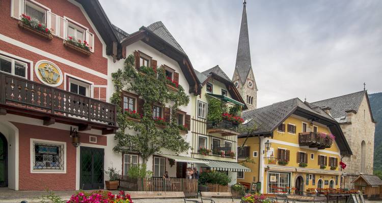 Colorful European town with a church tower and nature backdrop.