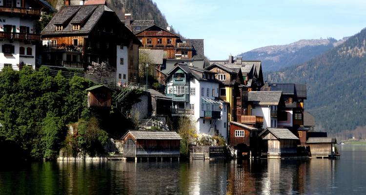 Traditional houses lining a lakeside in a mountainous area.